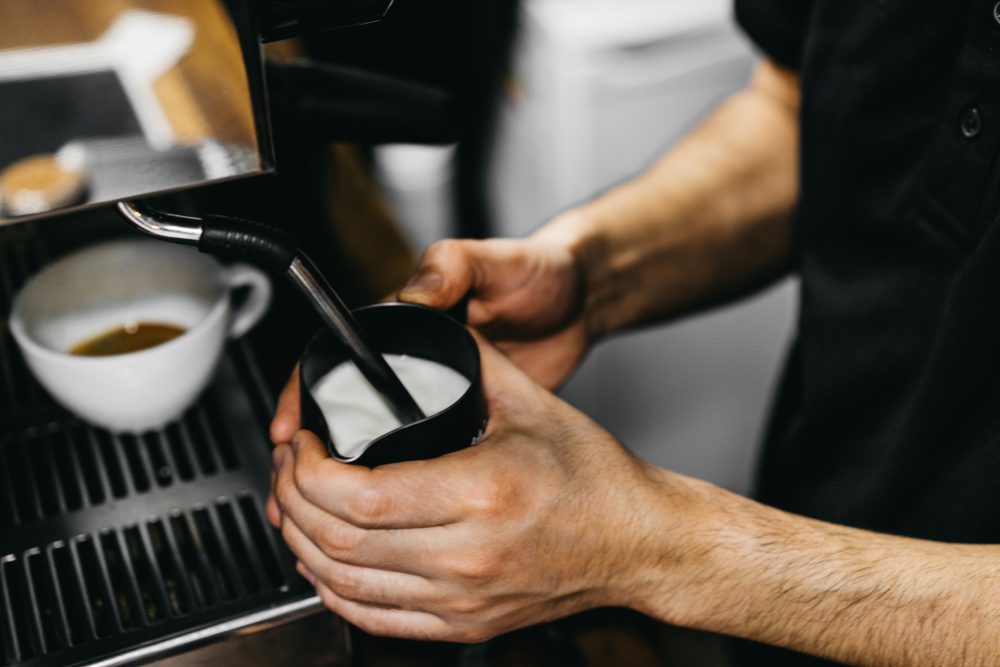 Milch wird für Cappuccino aufgeschäumt